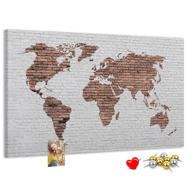 Kurkbord wereldkaart met een achtergrond van een bakstenen muur