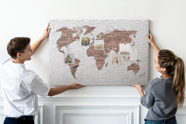 Kurkbord wereldkaart met een achtergrond van een bakstenen muur