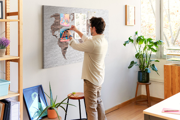 Kurkbord wereldkaart met een achtergrond van een bakstenen muur