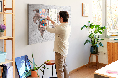 Kurkbord wereldkaart met een achtergrond van een bakstenen muur