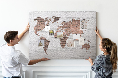 Kurkbord wereldkaart met een achtergrond van een bakstenen muur