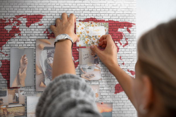 Kurkbord met afbeelding van de wereld op een bakstenen muur