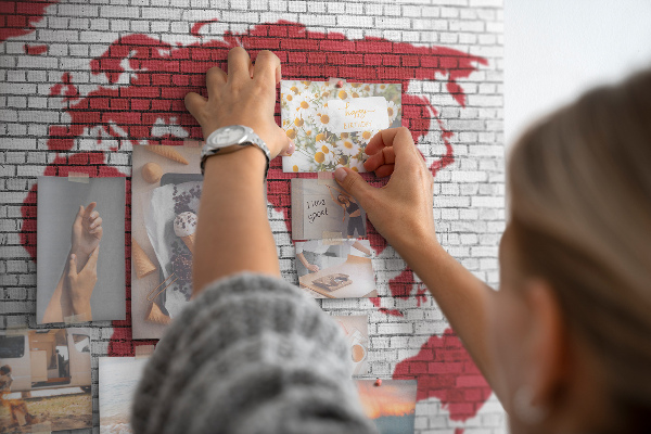 Kurkbord met afbeelding van de wereld op een bakstenen muur
