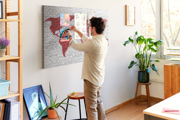 Kurkbord met afbeelding van de wereld op een bakstenen muur