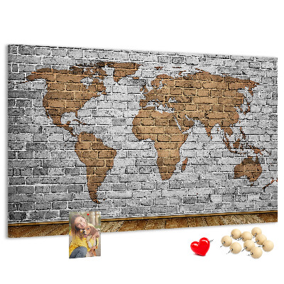Kurkbord wereldkaart op een bakstenen muur