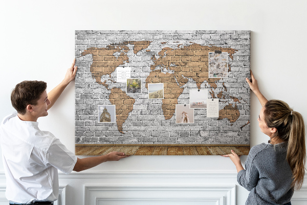Kurkbord wereldkaart op een bakstenen muur