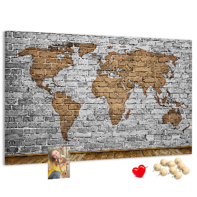Kurkbord wereldkaart op een bakstenen muur