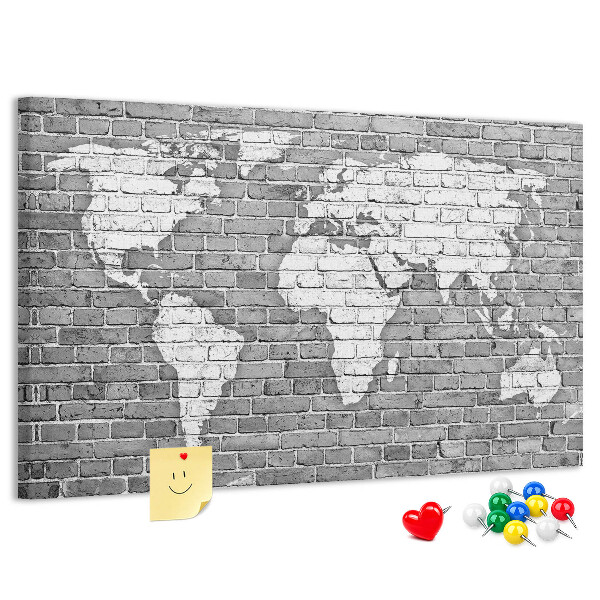 Kurken prikbord wereldkaart op een bakstenen muur