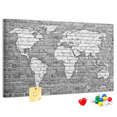 Kurken prikbord wereldkaart op een bakstenen muur