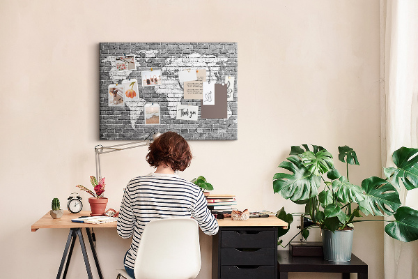 Kurken prikbord wereldkaart op een bakstenen muur
