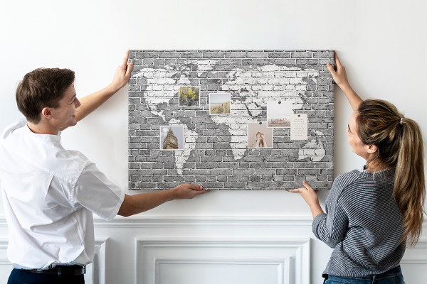 Kurken prikbord wereldkaart op een bakstenen muur