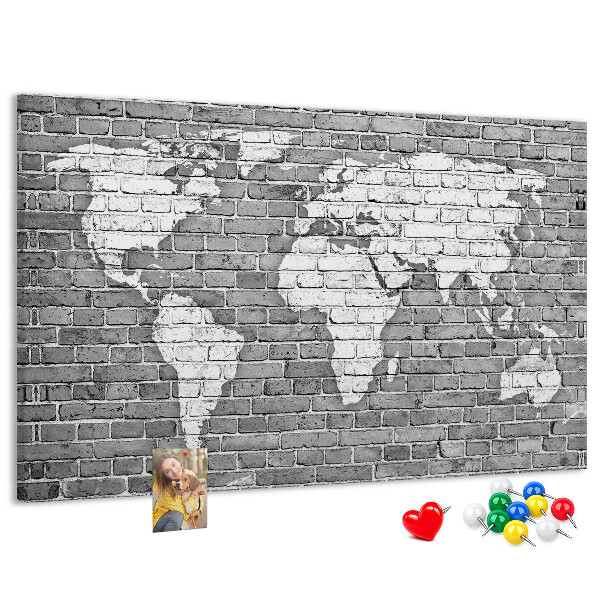 Kurken prikbord wereldkaart op een bakstenen muur