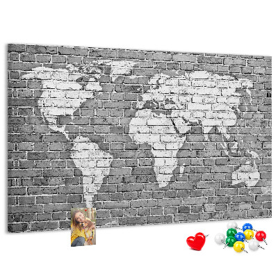 Kurken prikbord wereldkaart op een bakstenen muur
