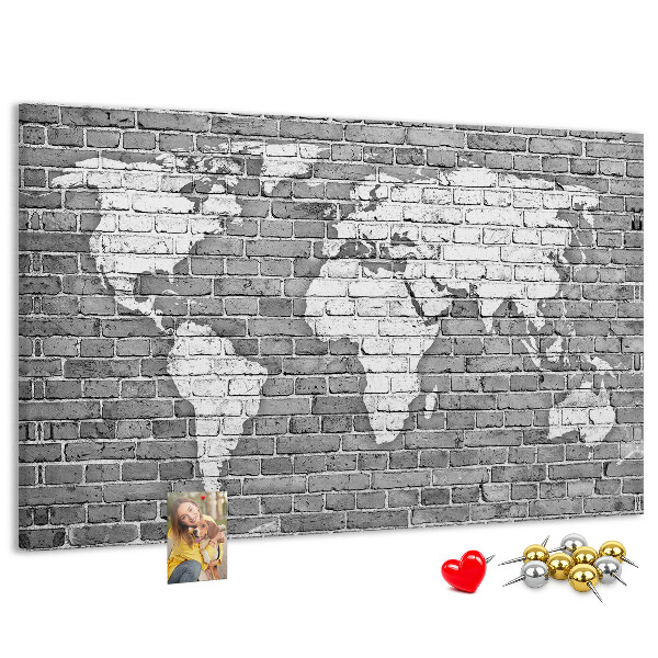 Kurken prikbord wereldkaart op een bakstenen muur