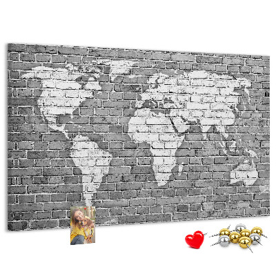 Kurken prikbord wereldkaart op een bakstenen muur