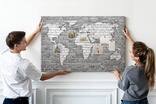 Kurken prikbord wereldkaart op een bakstenen muur