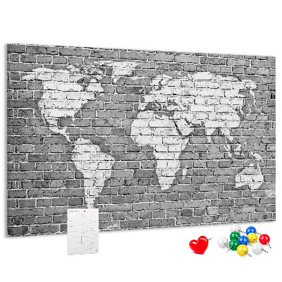 Kurken prikbord wereldkaart op een bakstenen muur