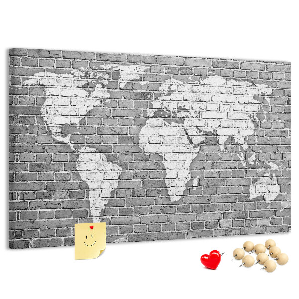 Kurken prikbord wereldkaart op een bakstenen muur