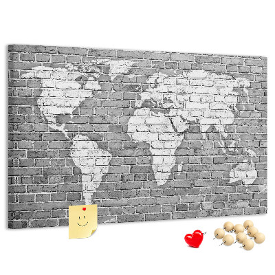 Kurken prikbord wereldkaart op een bakstenen muur