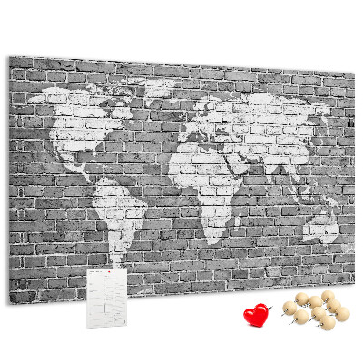 Kurken prikbord wereldkaart op een bakstenen muur
