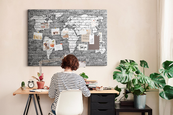 Kurken prikbord wereldkaart op een bakstenen muur