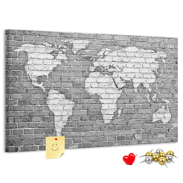 Kurken prikbord wereldkaart op een bakstenen muur