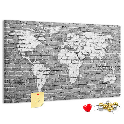 Kurken prikbord wereldkaart op een bakstenen muur