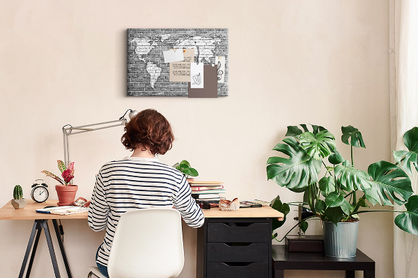 Kurken prikbord wereldkaart op een bakstenen muur