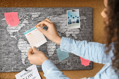 Kurken prikbord wereldkaart op een bakstenen muur