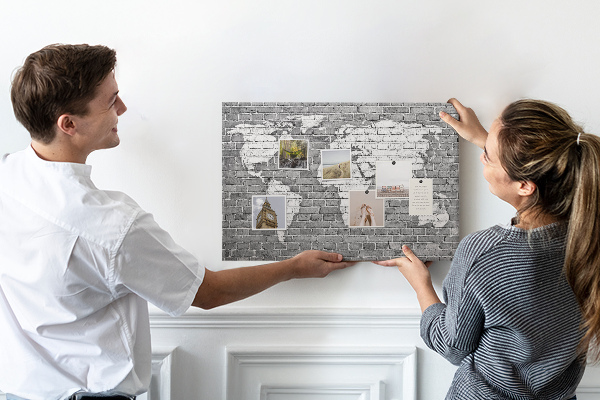 Kurken prikbord wereldkaart op een bakstenen muur