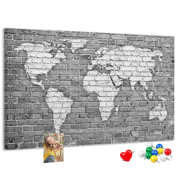 Kurken prikbord wereldkaart op een bakstenen muur