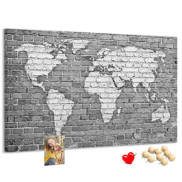 Kurken prikbord wereldkaart op een bakstenen muur