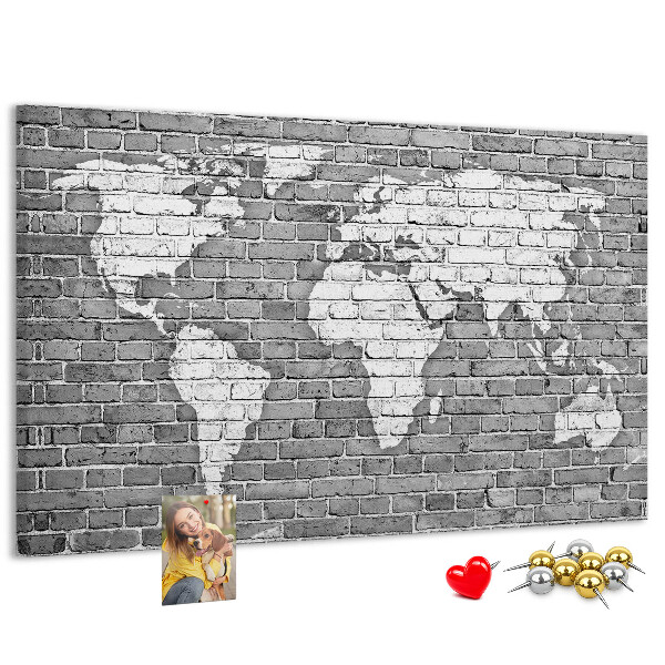 Kurken prikbord wereldkaart op een bakstenen muur