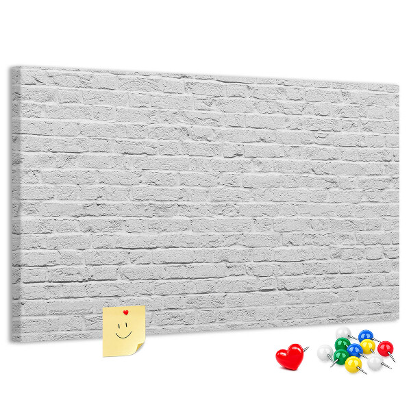 met afbeelding van witte bakstenen muur met kleurrijke punaises