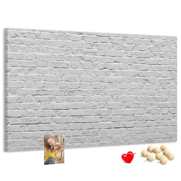 Kurk prikbord met afbeelding van witte bakstenen muur met kleurrijke punaises