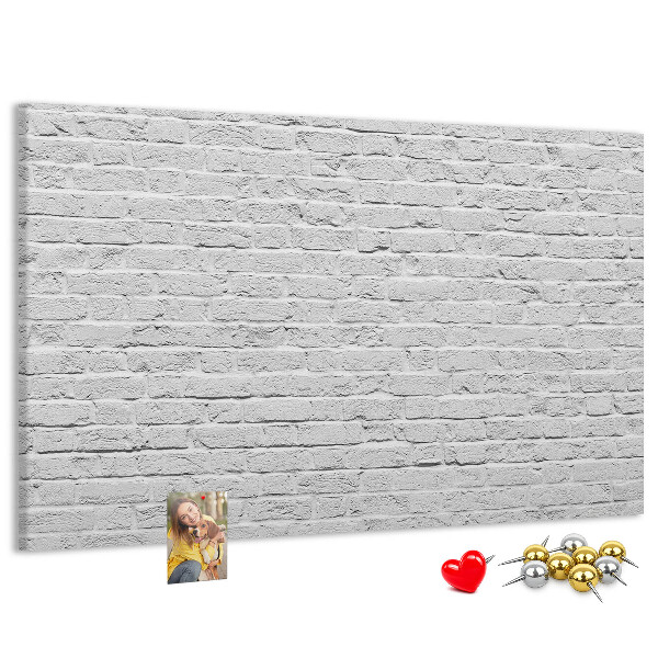 Kurk prikbord met afbeelding van witte bakstenen muur met kleurrijke punaises
