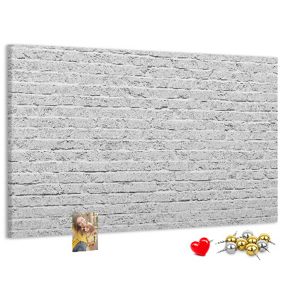 Kurk prikbord met afbeelding van witte bakstenen muur met kleurrijke punaises