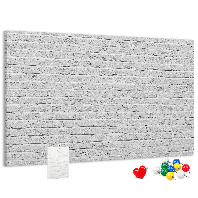 Kurk prikbord met afbeelding van witte bakstenen muur met kleurrijke punaises