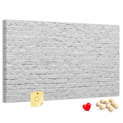 Kurk prikbord met afbeelding van witte bakstenen muur met kleurrijke punaises