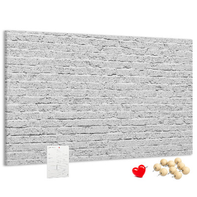 Kurk prikbord met afbeelding van witte bakstenen muur met kleurrijke punaises