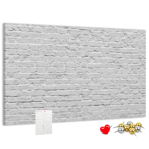 Kurk prikbord met afbeelding van witte bakstenen muur met kleurrijke punaises