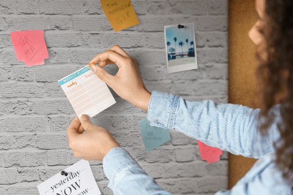 Kurk prikbord met afbeelding van witte bakstenen muur met kleurrijke punaises