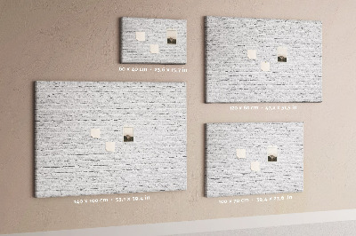 Kurk prikbord met afbeelding van witte bakstenen muur met kleurrijke punaises