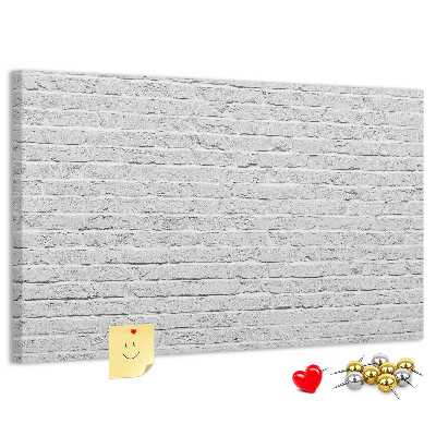 Kurk prikbord met afbeelding van witte bakstenen muur met kleurrijke punaises