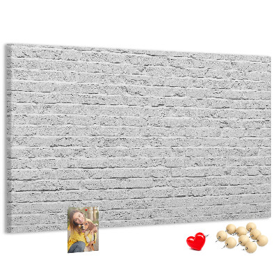 Kurk prikbord met afbeelding van witte bakstenen muur met kleurrijke punaises