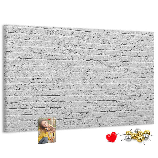 Kurk prikbord met afbeelding van witte bakstenen muur met kleurrijke punaises