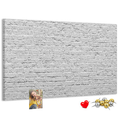 Kurk prikbord met afbeelding van witte bakstenen muur met kleurrijke punaises