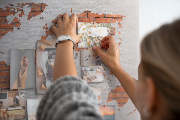 Kurkbord wereldkaart tegen een bakstenen muur
