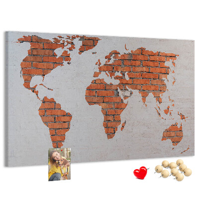 Kurkbord wereldkaart tegen een bakstenen muur