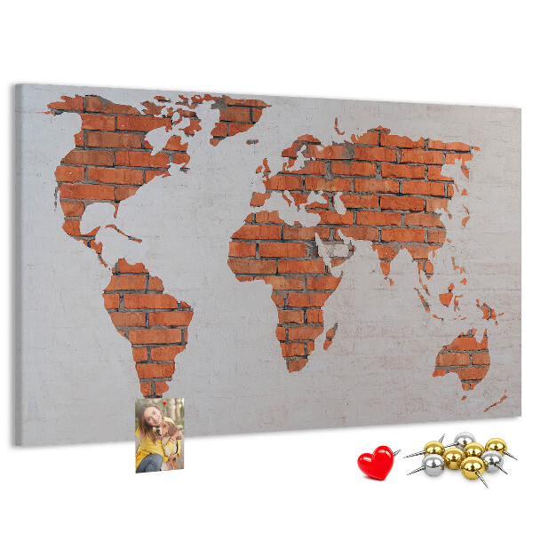 Kurkbord wereldkaart tegen een bakstenen muur